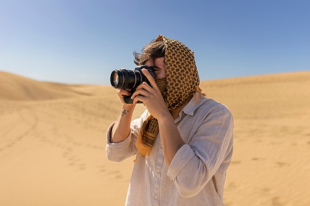 Foto gratuita uomo di vista laterale che scatta foto con la fotocamera