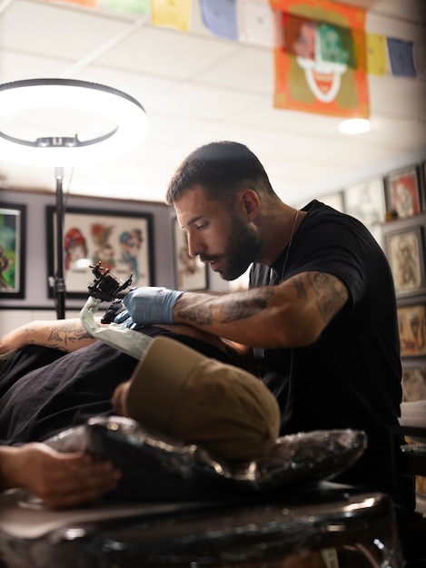 Side view man tattooing customer