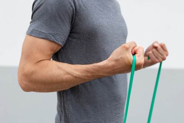 Side view man training with elastic band