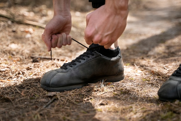 Side view man tying his shoelaces