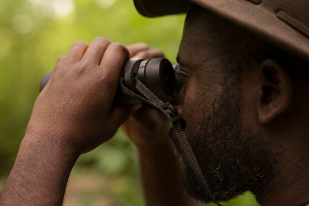 Side view man using binoculars