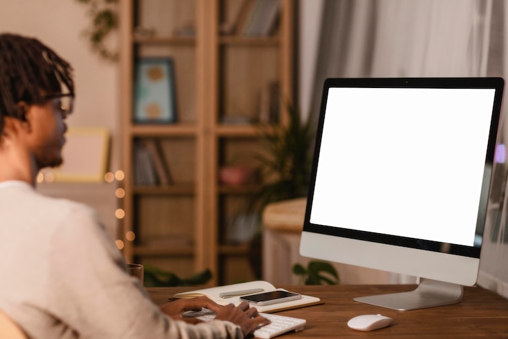 Free Photo side view of man using computer at home