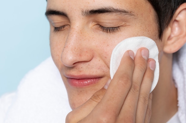 Side view man using cotton pad