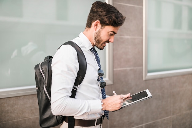 Foto gratuita vista laterale di un uomo che utilizza la tavoletta digitale