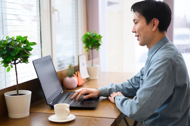 Free photo side view man using laptop