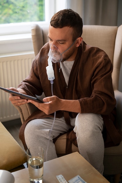 Side view man using a nebulizer