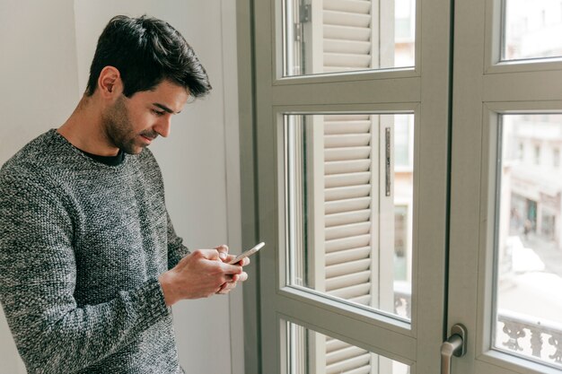 窓の近くでスマートフォンを使用している側の人