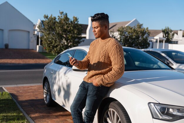 Uomo con vista laterale che utilizza lo smartphone all'aperto