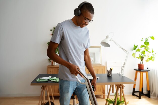 Side view man vacuuming floor