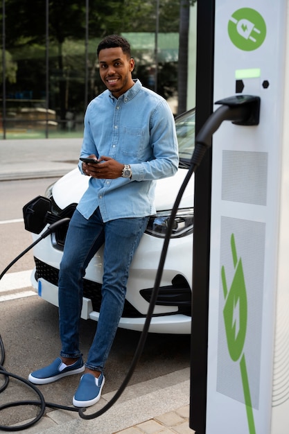 Side view man waiting for car to charge