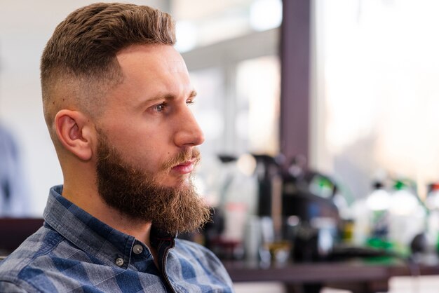 Free photo side view man waiting for a haircut