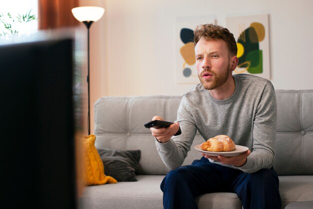 Side view man watching news on tv