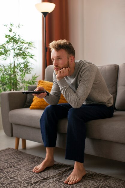 Side view man watching news on tv