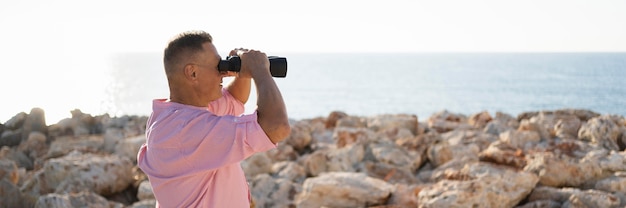 Free photo side view man watching through binoculars