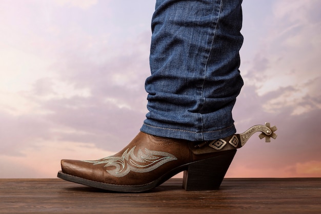 Free photo side view man wearing boots cowboy inspiration