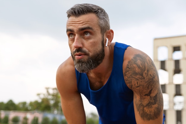 Free photo side view man wearing earphones