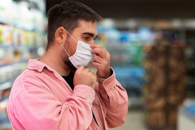 Foto gratuita uomo con vista laterale che indossa una maschera per il viso