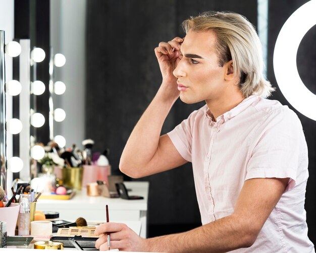 Free photo side view man wearing make-up