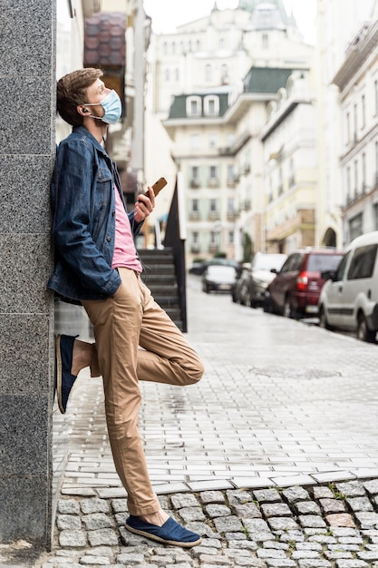 Side view man wearing a medical mask outside