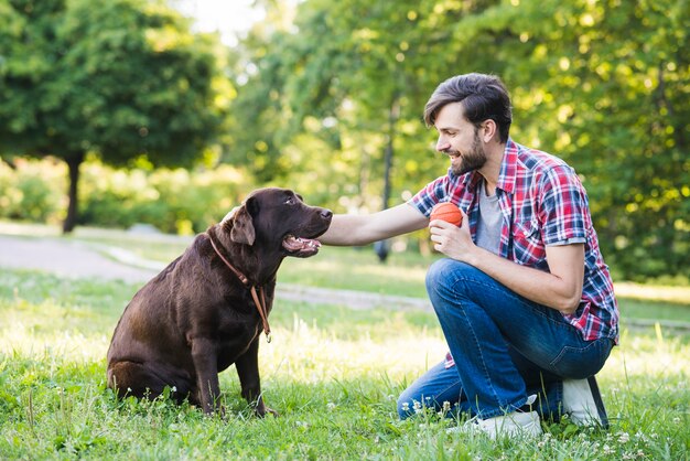 彼の犬を草の上に置いた男の側面図