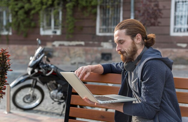 Side view of man with laptop in the city