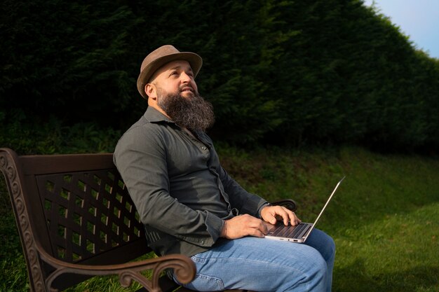 Side view man with laptop outdoors