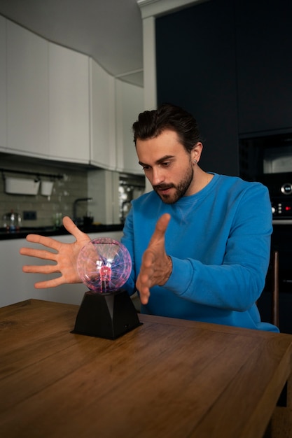 Side view man with a plasma ball