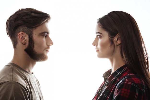 Free photo side view. man and woman facing each other, eyes open.