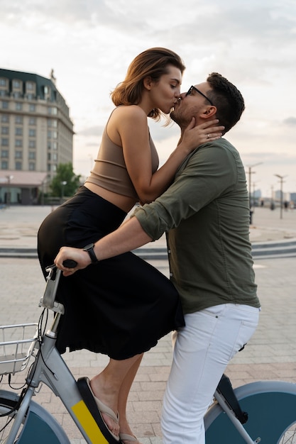 Foto gratuita uomo e donna di vista laterale che baciano sulla bicicletta