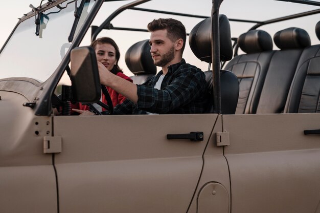 Side view of man and woman traveling by car