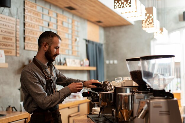 Side view of man working in coffee shop