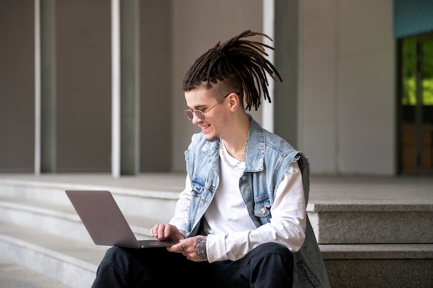 Side view man working on laptop outdoors