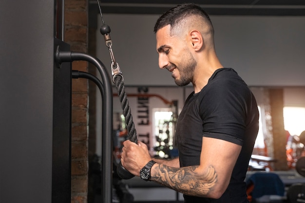 Free photo side view man working out at gym