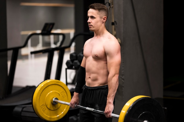 Side view man workout with weightlifting