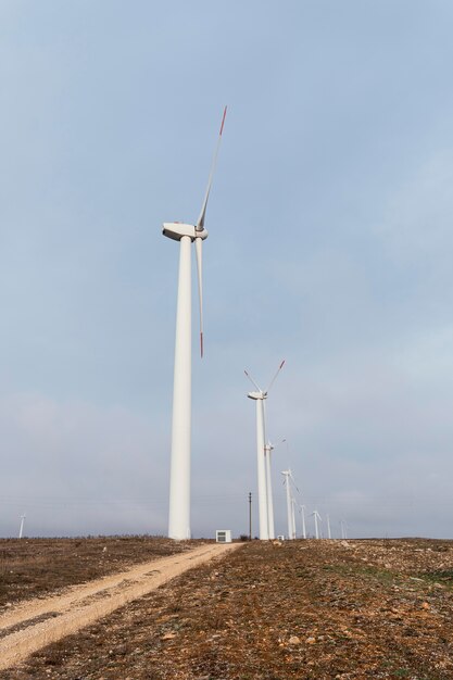 Side view of many wind turbines in the field generating energy