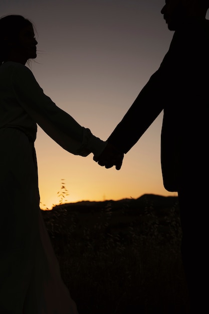 Side view married couple holding hands