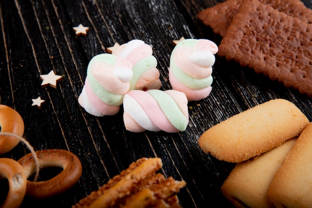 Free photo side view marshmallows with cookies and stars on the table