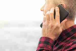 Free photo side view mature man talking on the phone close-up