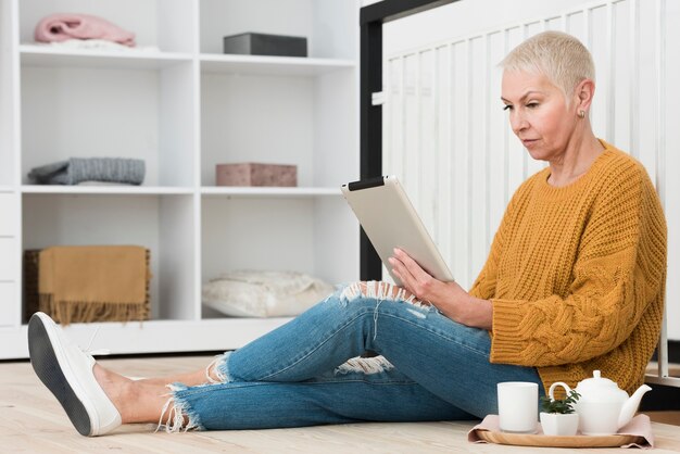 Side view of mature woman looking at tablet