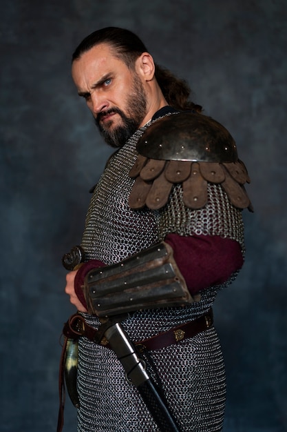 Free photo side view medieval soldier posing in studio