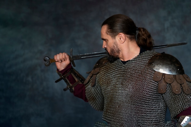 Free photo side view medieval soldier posing in studio