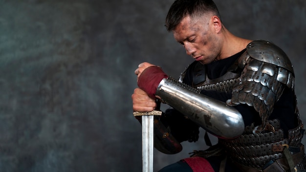 Free photo side view medieval soldier posing in studio
