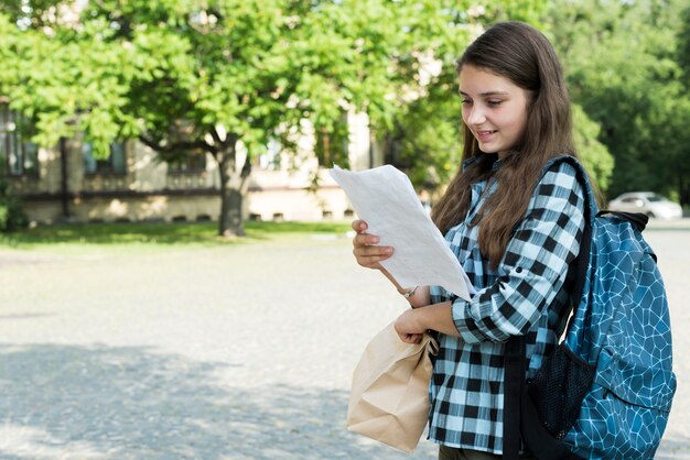 Side view  medium shot of highschool girl reading notes