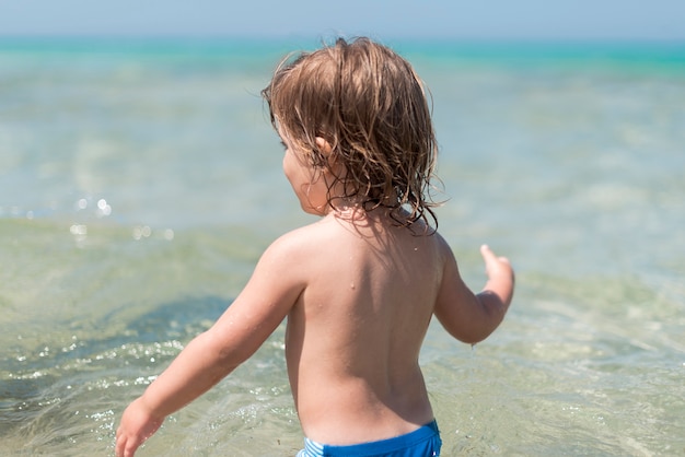 Free photo side view medium shot of kid at the beach