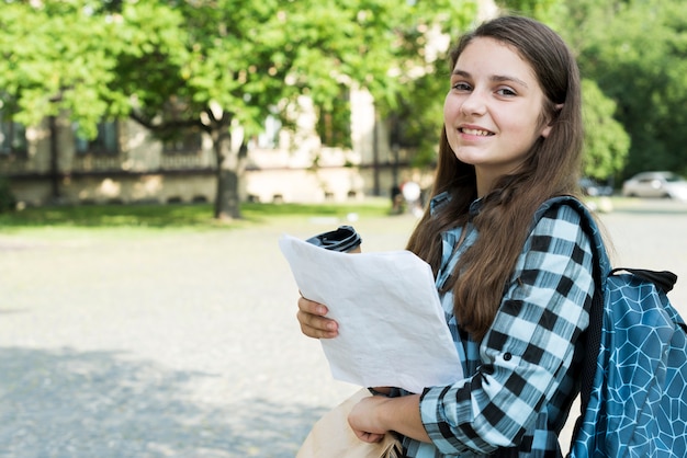 Free photo side view medium shot of school girl holding notes