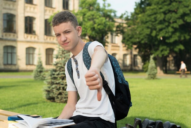 Side view medium shot of sitting disappointed teenage boy