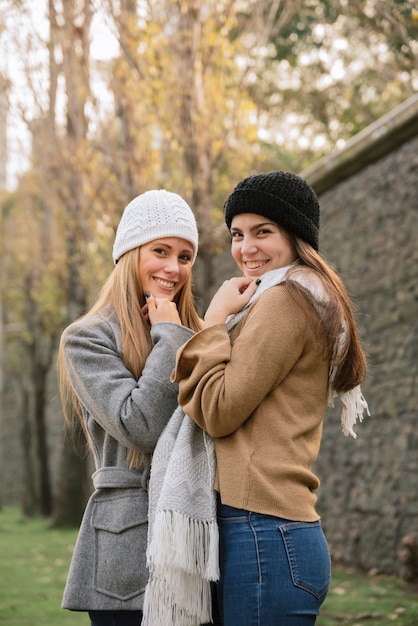 Side view medium shot of two smiling women in the park