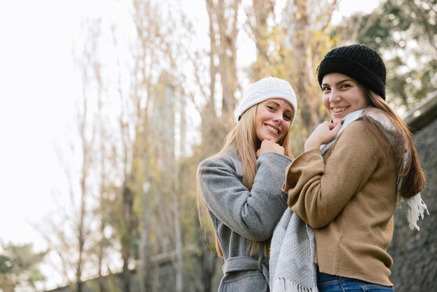 Side view medium shot of two smiling women in the park