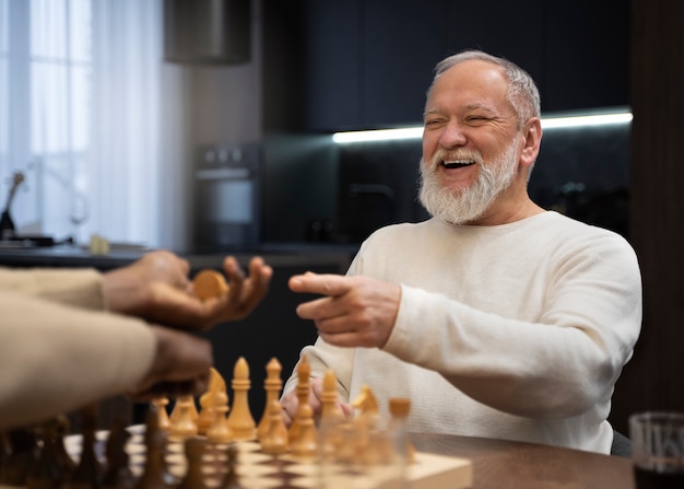 Free photo side view men playing chess indoors