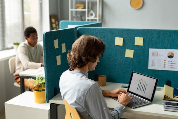 Foto gratuita uomini di vista laterale che lavorano con le partizioni